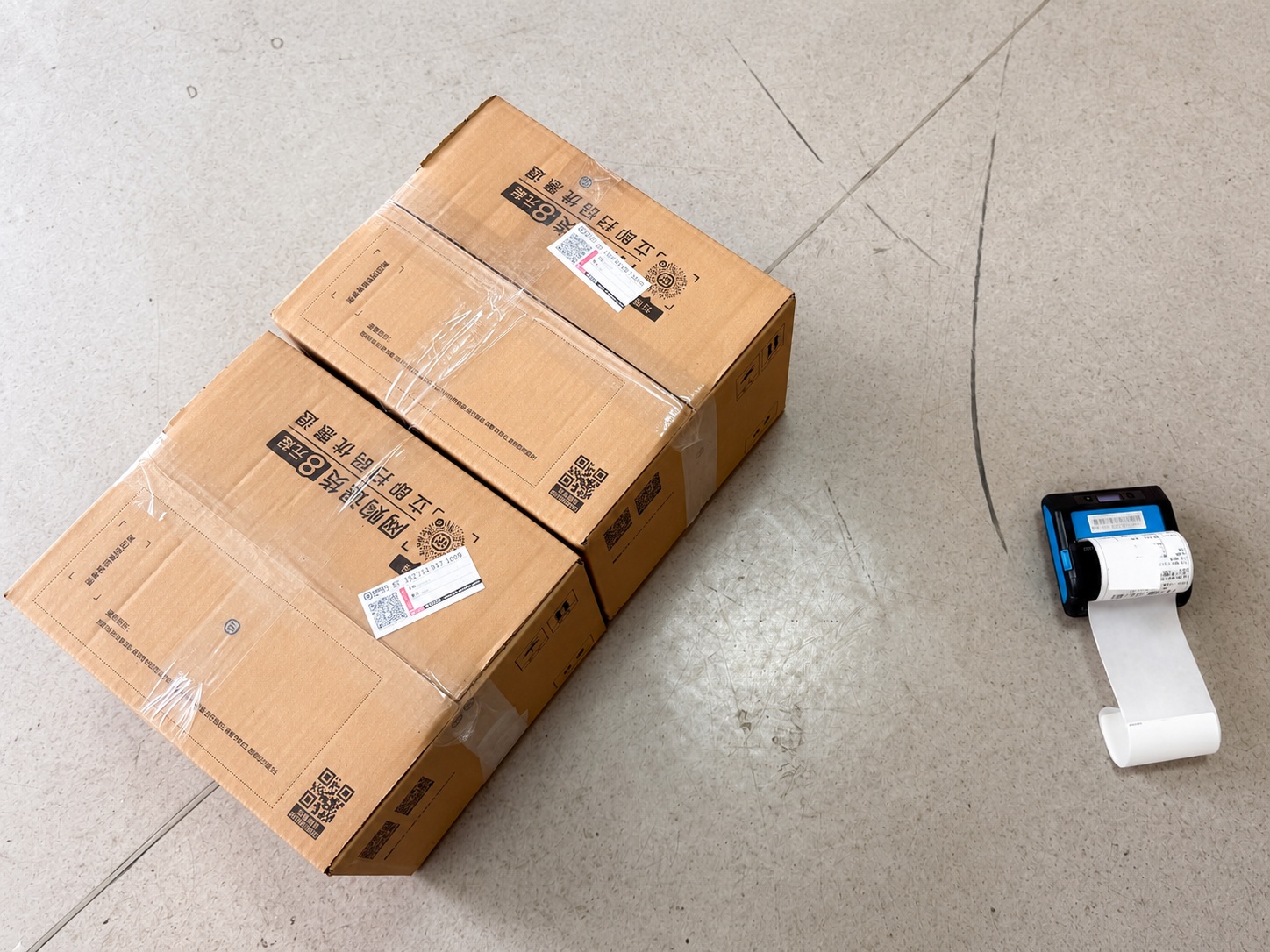 Packed shopping orders alongside a shipping label printer